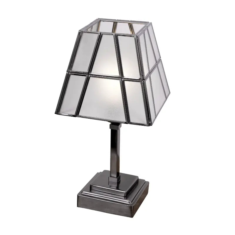 Table lamp with geometric glass shade on a white background