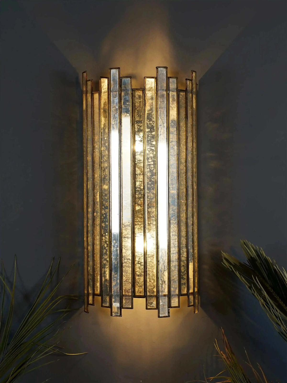 Staggered brass wall lamp with silver antique glass and handcrafted brass detailing by ILLUMEA