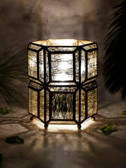 Decorative hexagonal lantern with a warm glow on a dark background