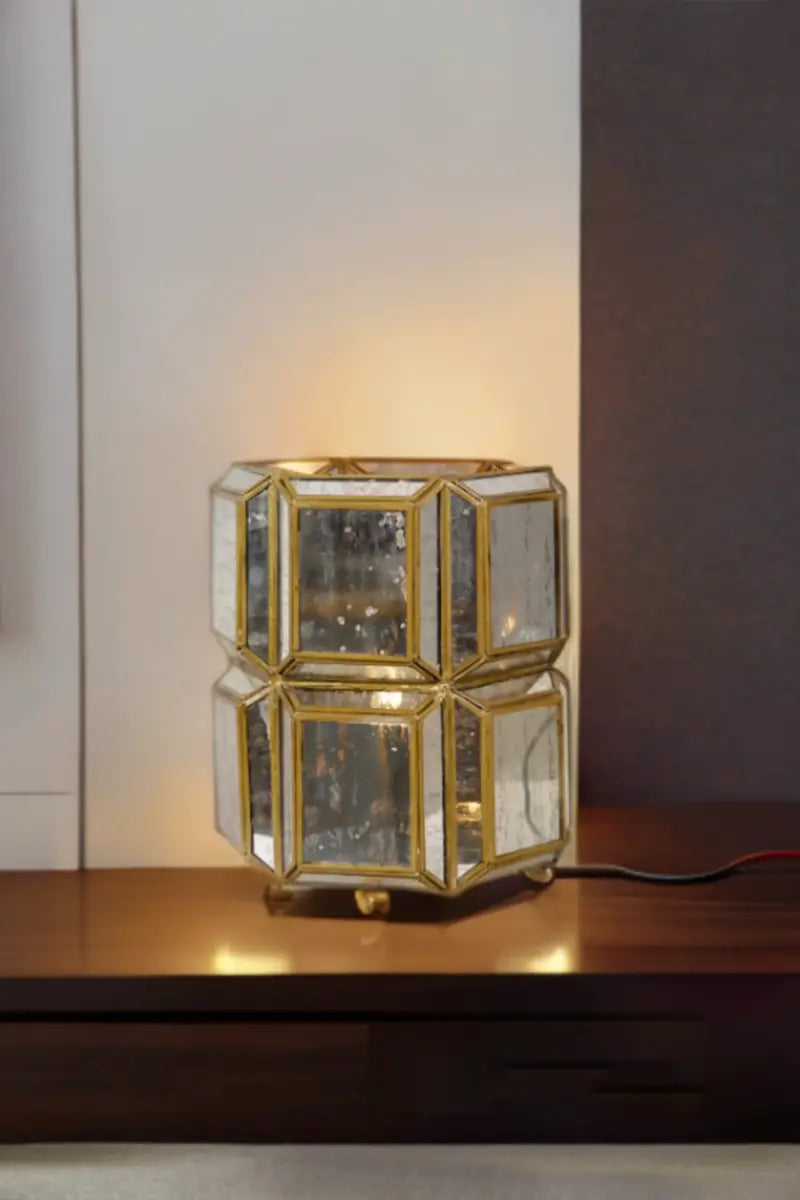 Decorative table lamp with geometric glass design on a wooden surface.