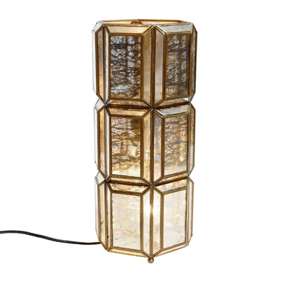 Decorative table lamp with geometric glass design on a white background