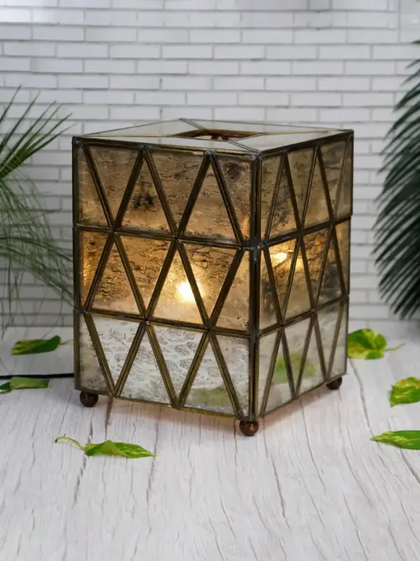 Decorative geometric lantern on a white surface with a white brick wall background