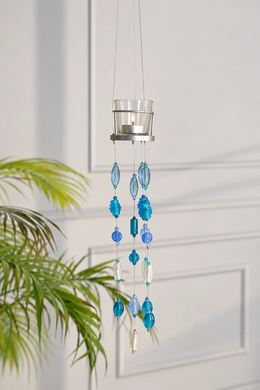 Decorative Blue Glass Hanging Votive – ILLUMEA luxury home décor accent combining a clear glass candle holder, metallic frame and cascading beaded strands for a beautiful ambient display