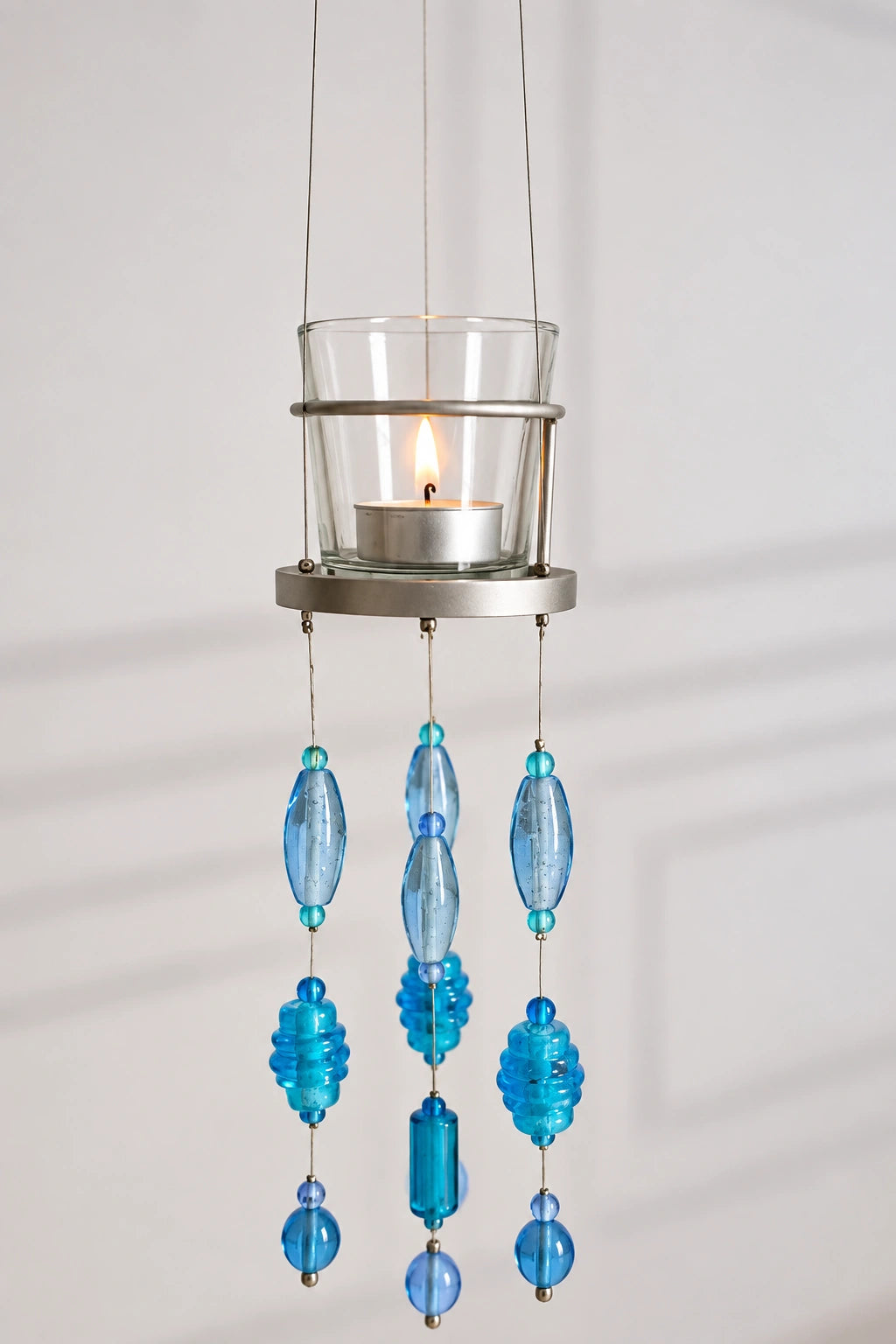 Blue Glass Beaded Hanging Votive – ILLUMEA elegant suspended tealight holder with transparent glass candle cup and multiple strands of handcrafted blue, aqua and turquoise glass beads