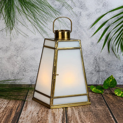 Decorative white glass lantern with a tapered geometric silhouette and brass frame, designed by ILLUMEA for sophisticated interiors