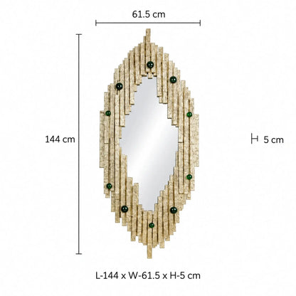 Designer Gold Wall Mirror – ILLUMEA statement mirror featuring an elongated geometric silhouette, layered cast metal strips with textured detailing and emerald green decorative accents