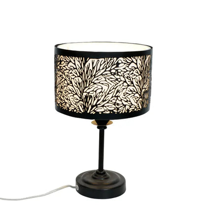 Table lamp with a black base and a decorative lampshade featuring a leaf pattern on a white background.