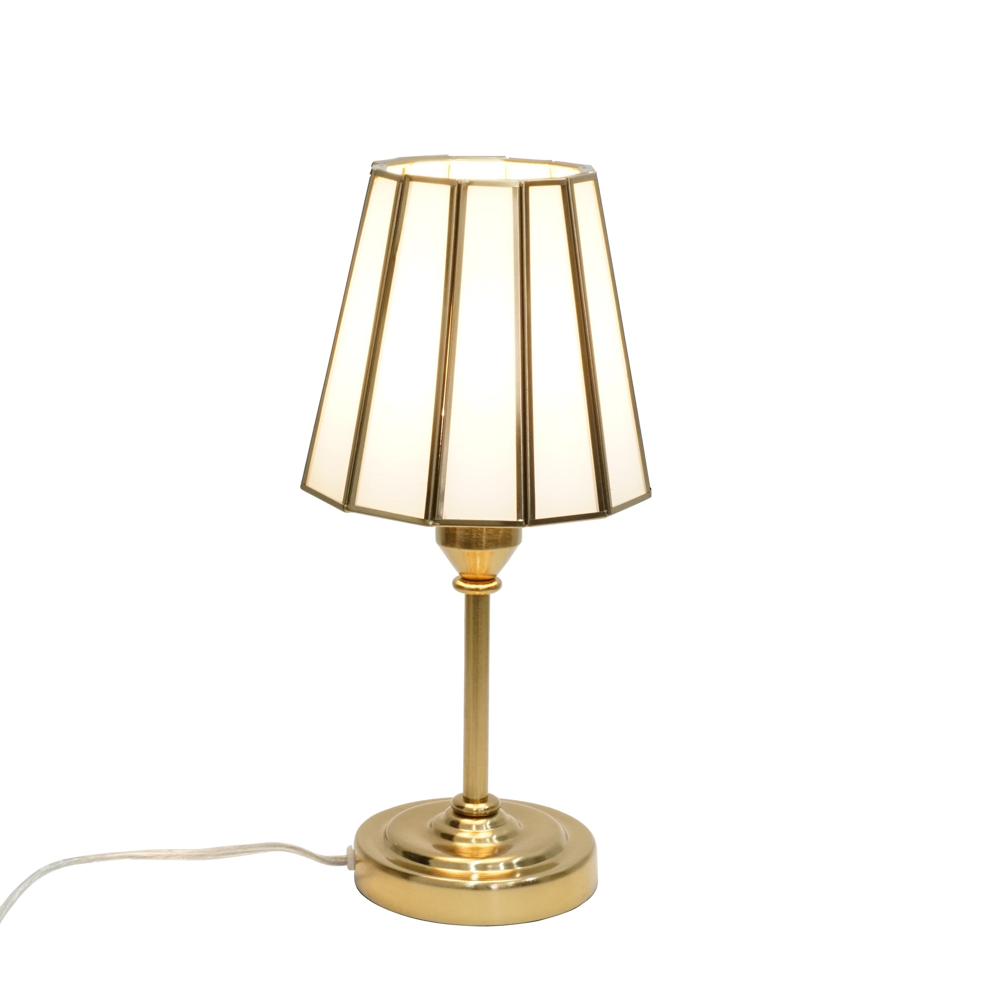 Gold table lamp with a white shade on a white background