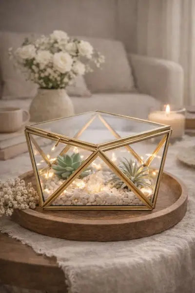 Decorative terrarium with lights on a wooden tray in a cozy living room setting.