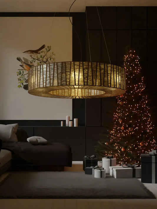 Decorative lamp hanging above a bed in a room with a Christmas tree and presents.